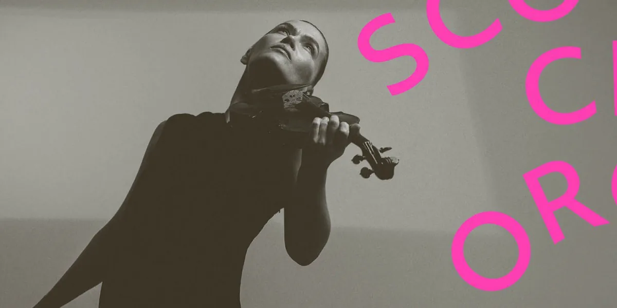 Mari Samuelsen holds her violin and wears a long black dress